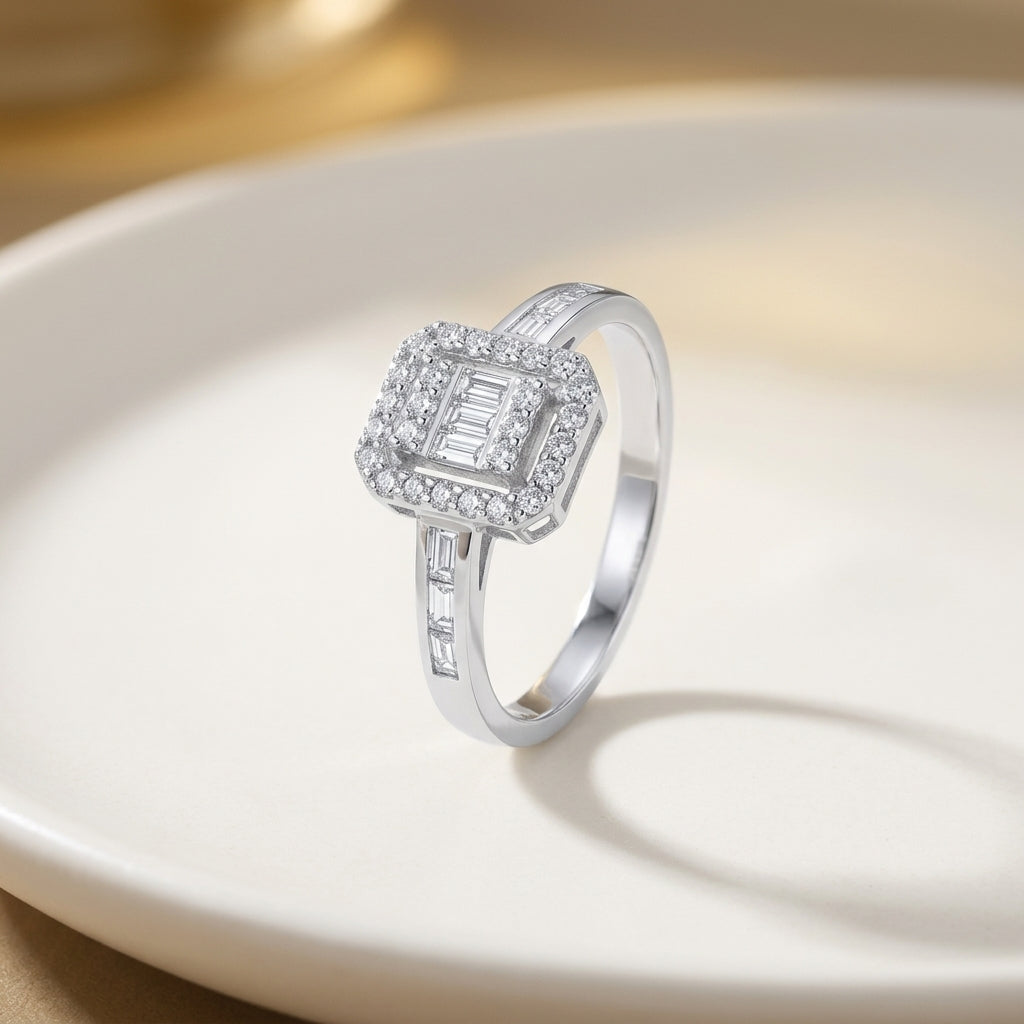 An emerald-cut diamond halo engagement ring in solid 14ct white gold, shown against an ivory background.